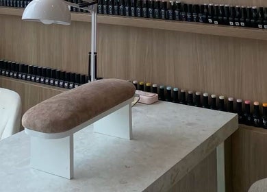 Poste de manucure moderne chez Nail Crest, Clichy, Île-de-France, FR, avec étagères de vernis colorés.