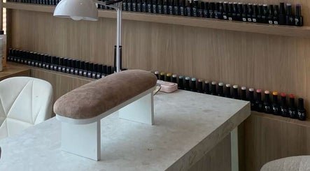 Poste de manucure moderne chez Nail Crest, Clichy, Île-de-France, FR, avec étagères de vernis colorés.