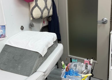 Comfortable nail treatment room at QT Nail Studio, Buford, Georgia, US, featuring a plush bed and organized supplies.