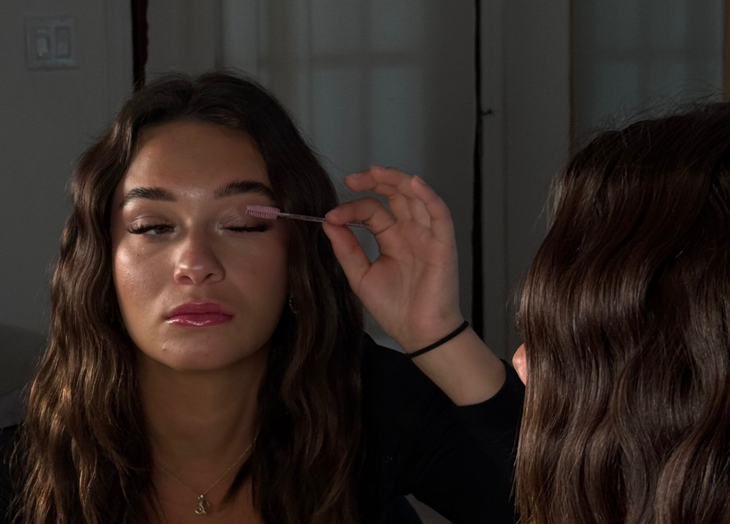 Woman applying mascara at Pink Lashes, Saint-basile-le-grand, Québec, CA, in front of a mirror.