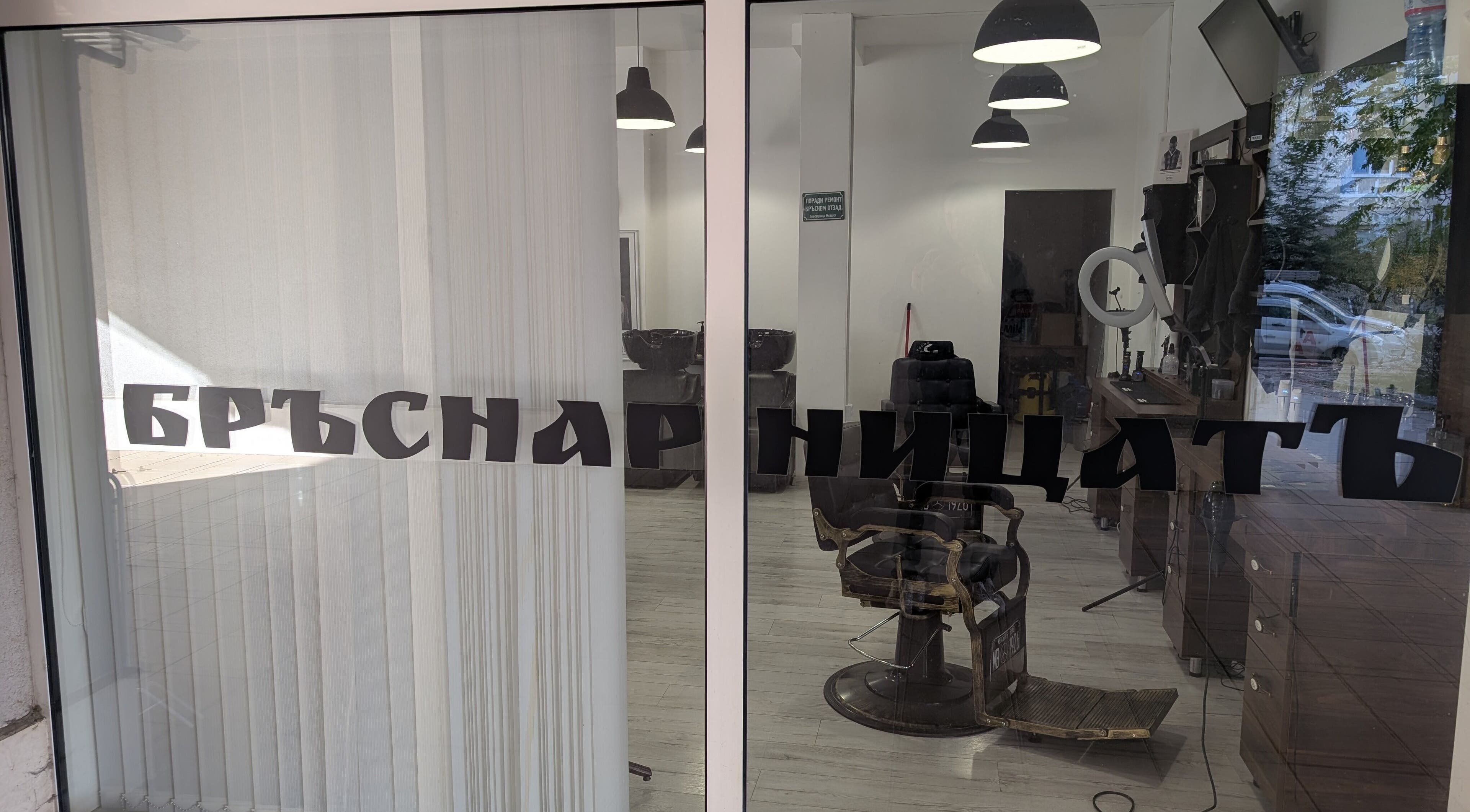 Изглед към интериора на БръснарницатЪ Младост 4, София, Област София, BG през стъклена витрина.