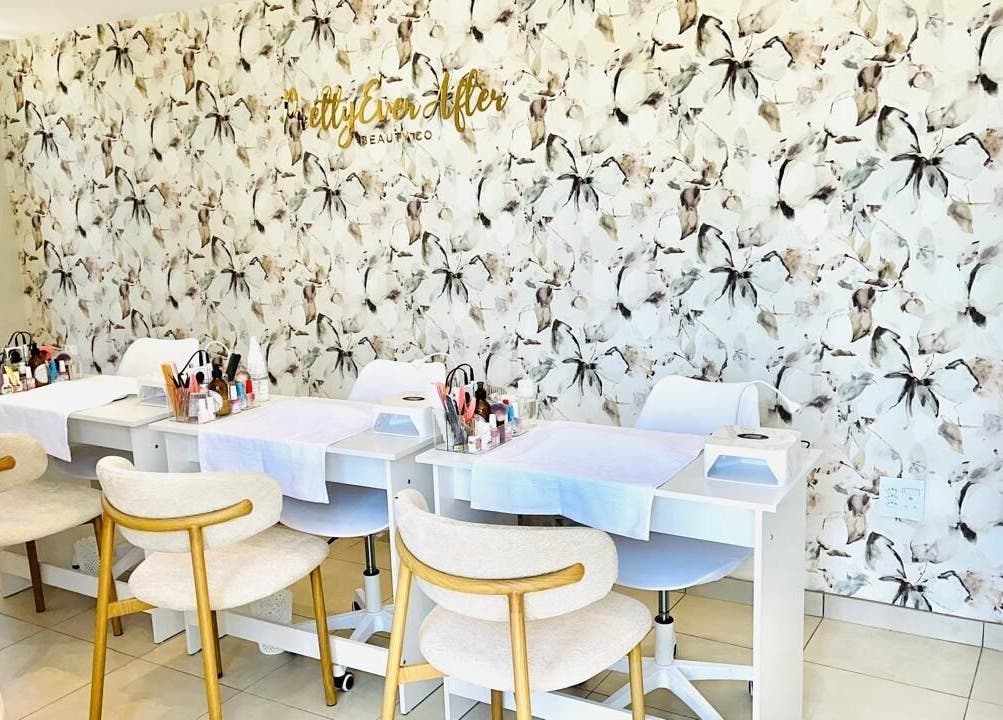 Pretty Ever After salon interior with floral walls in Benoni, Gauteng, ZA, featuring stylish manicure stations.