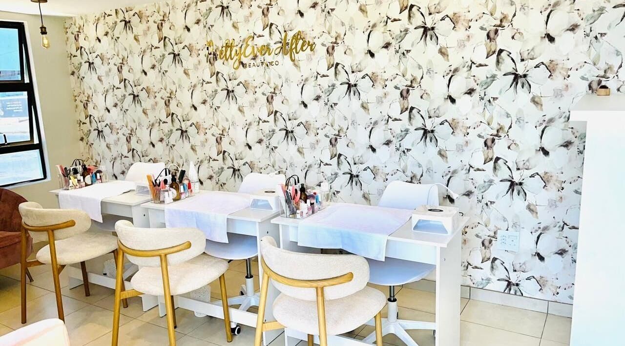 Pretty Ever After salon interior with floral walls in Benoni, Gauteng, ZA, featuring stylish manicure stations.