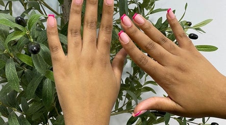 Hands with pink-tipped nails at Lyn's beauty studio in Sandton, Gauteng, ZA, showcasing elegant nail art.