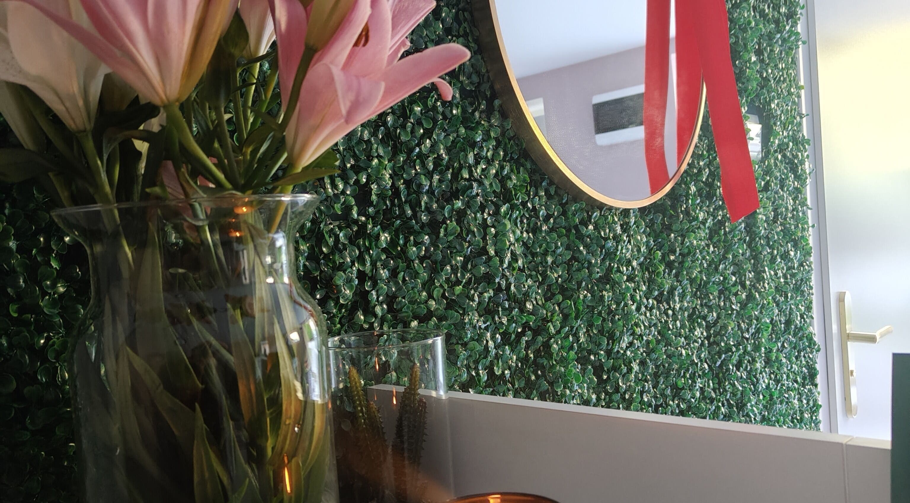 Wazon z różowymi liliami na zielonej ściance w Piękno&Pasja, Miechowice, Mazowieckie, PL.