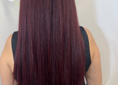 Long, sleek burgundy hair extensions at Extensioneslyas in Chula Vista, California, US.