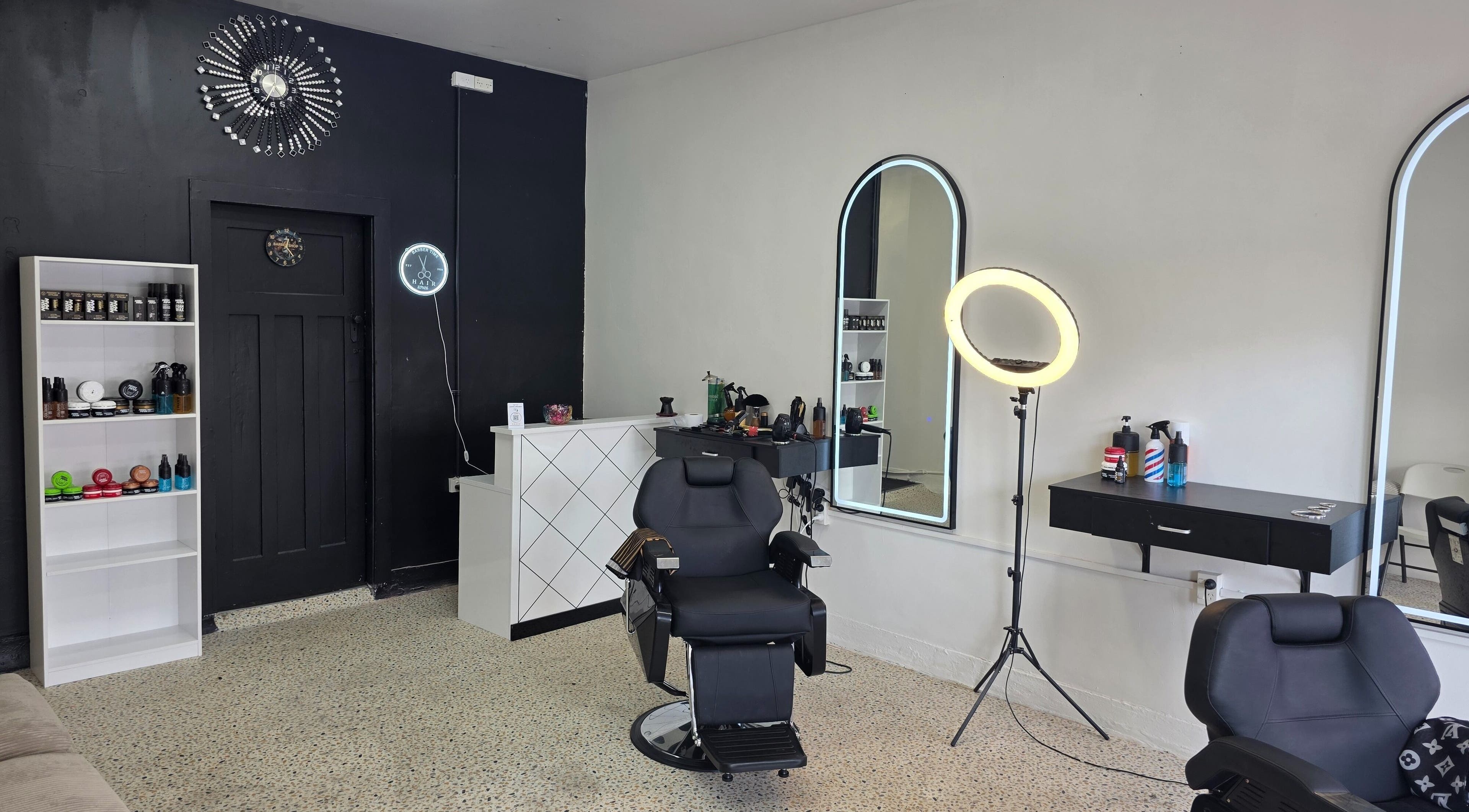 Modern Barbertime.nz salon with stylish decor in Auckland, Auckland, NZ featuring black chairs and stylish mirrors.