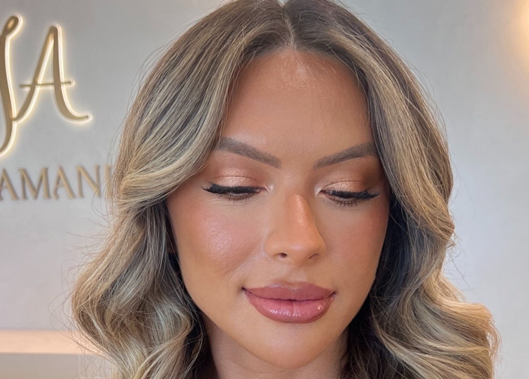 Woman with glowing makeup at By Brooke Lee, Perth, Western Australia, AU salon, highlighting soft waves and perfect brows.