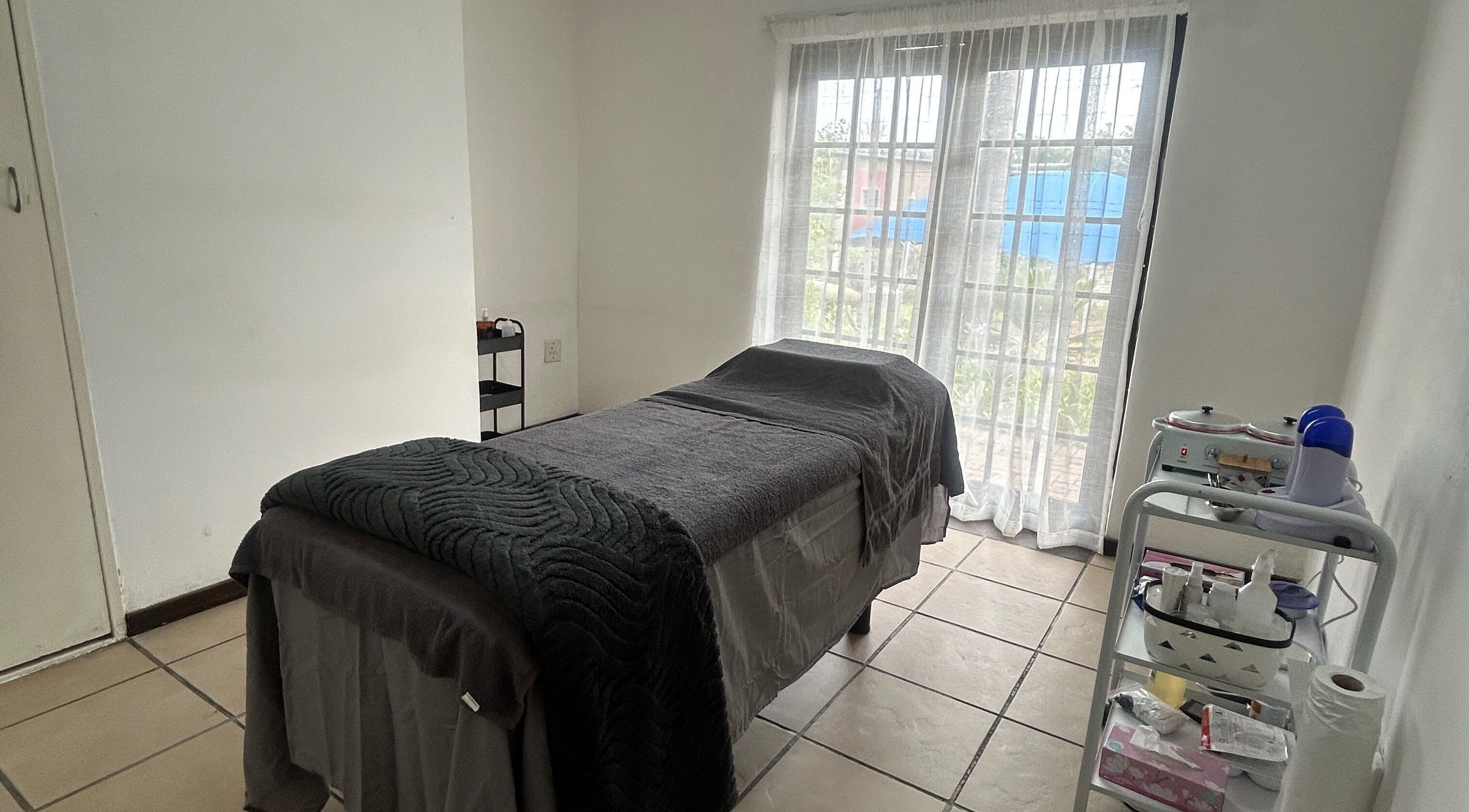 Tranquil massage room at Beautifly Garden, Sandton, Gauteng, ZA, featuring a comfortable treatment bed.