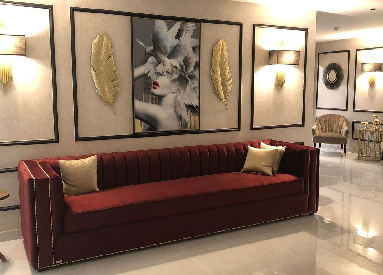 Stylish lounge area of Malda Salon - ملدا صالون in Jeddah, Makkah Province, SA, featuring a red velvet sofa.