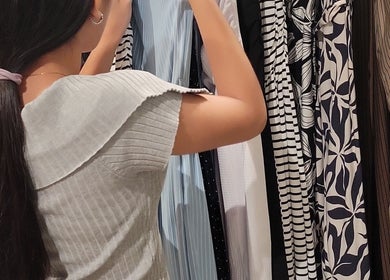 A woman browsing chic dresses at Anahí's, Mérida, Yucatán, MX, showcasing diverse fashion styles.
