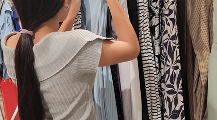 A woman browsing chic dresses at Anahí's, Mérida, Yucatán, MX, showcasing diverse fashion styles.