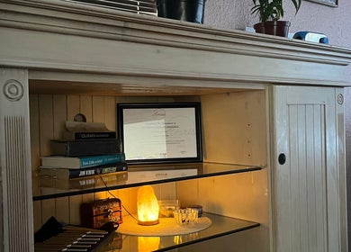 Serene shelf at H.E.R - Heal. Embody. Rise, Cape Town, with a glowing salt lamp and wellness books.