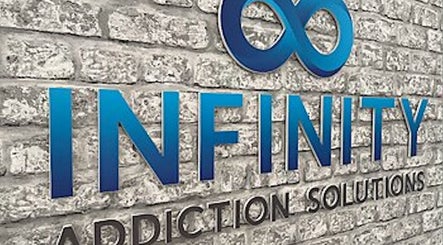 Infinity Addiction Solutions sign on a brick wall, Essex, England, GB