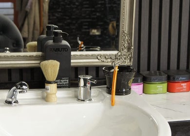 Stylish salon countertop scene at MOSS Salon, London, England, GB with grooming products and ornate mirror.