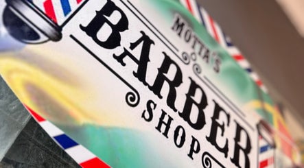 Enseigne rétro de Motta’s Barber Shop à Amadora, Lisboa, PT, avec couleurs rouge, blanche et bleue.