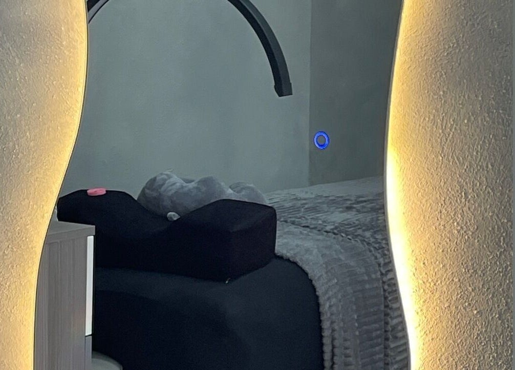 Cozy treatment room at Marleni Lash Browns Studio, La Vega, La Vega, DO with warm lighting and plush bedding.