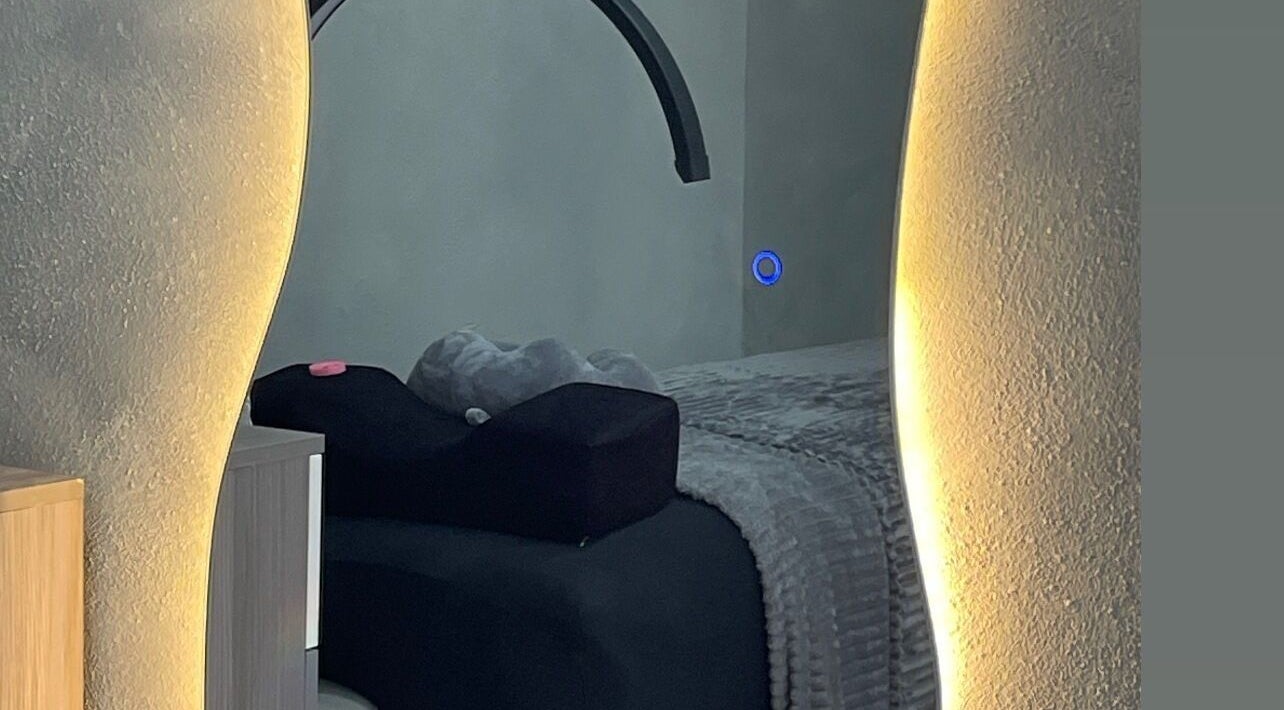 Cozy treatment room at Marleni Lash Browns Studio, La Vega, La Vega, DO with warm lighting and plush bedding.