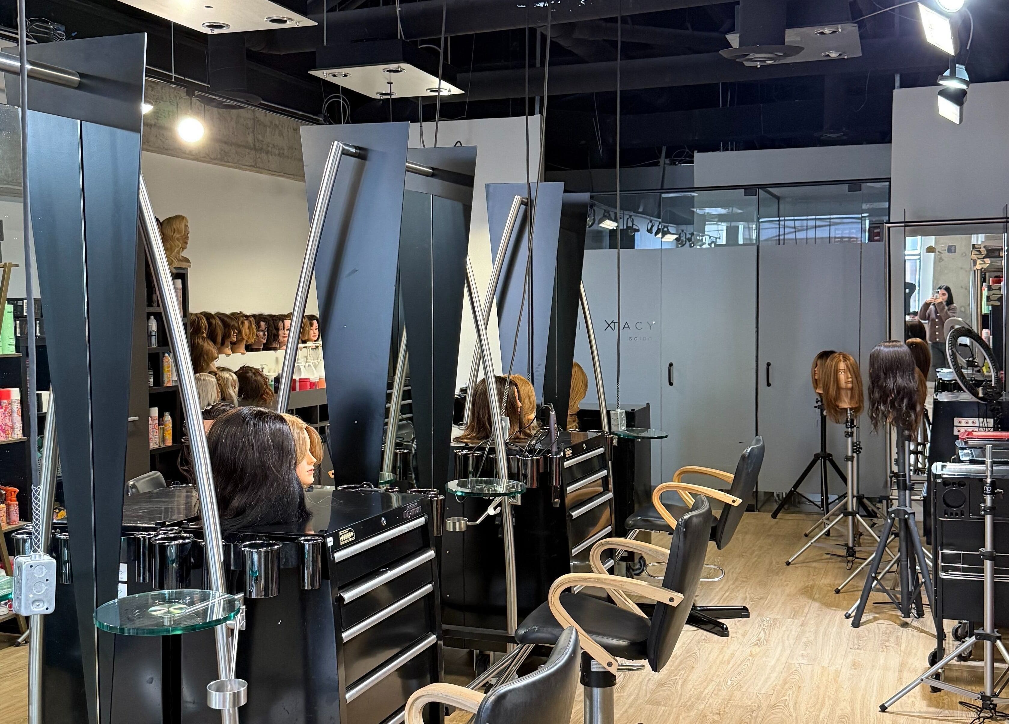 Chic salon interior at hairxtacy academy graduates in Burlington, Ontario, CA featuring modern styling stations.