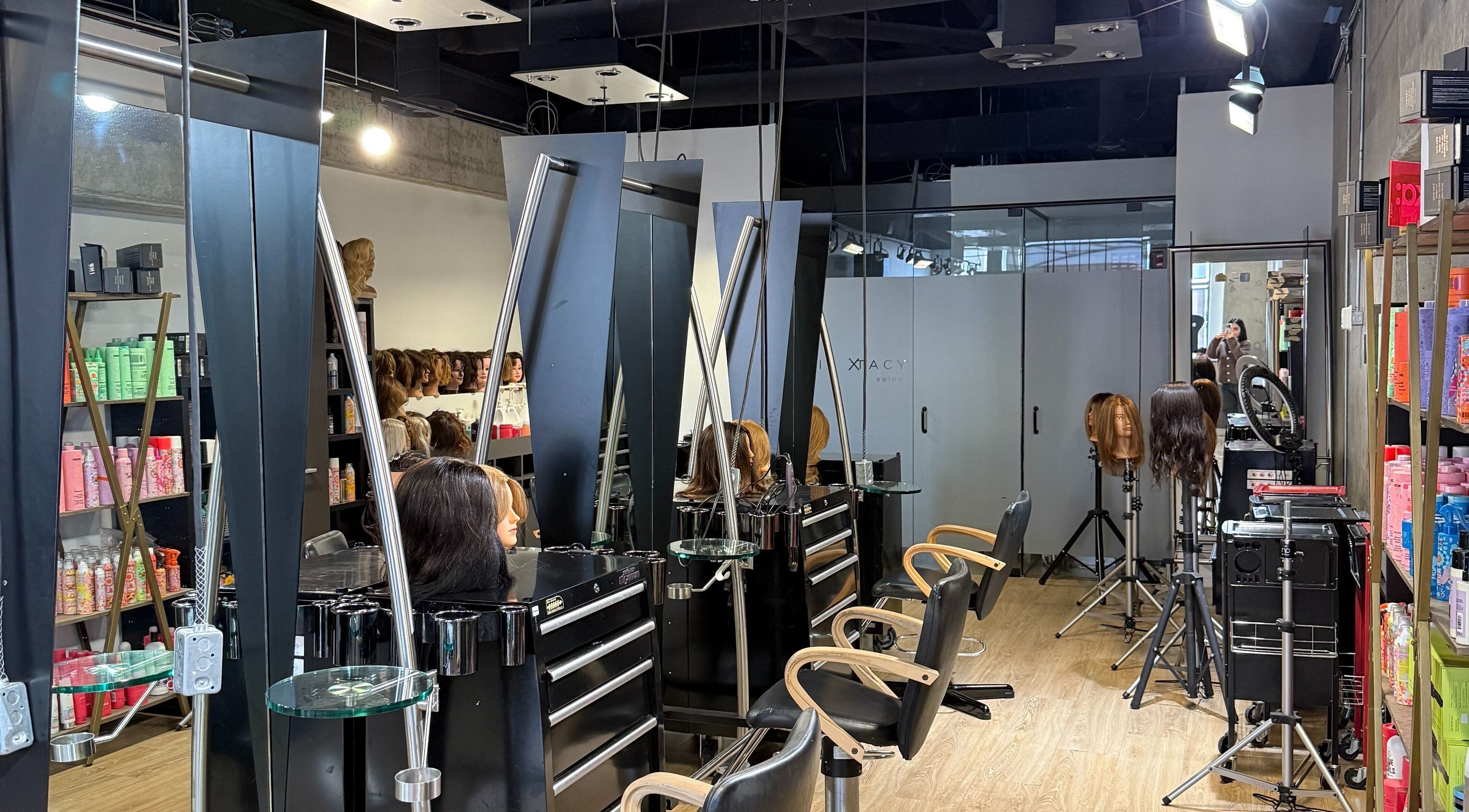 Chic salon interior at hairxtacy academy graduates in Burlington, Ontario, CA featuring modern styling stations.