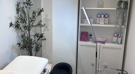 Relaxing treatment room at Lumora Aesthetics, London, England, GB, featuring a plush bed and elegant decor.