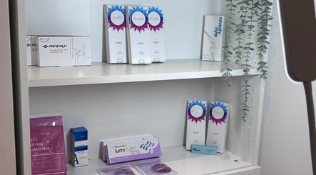 Beauty products on shelf at Lumora Aesthetics, London, England, GB showcasing skincare items.