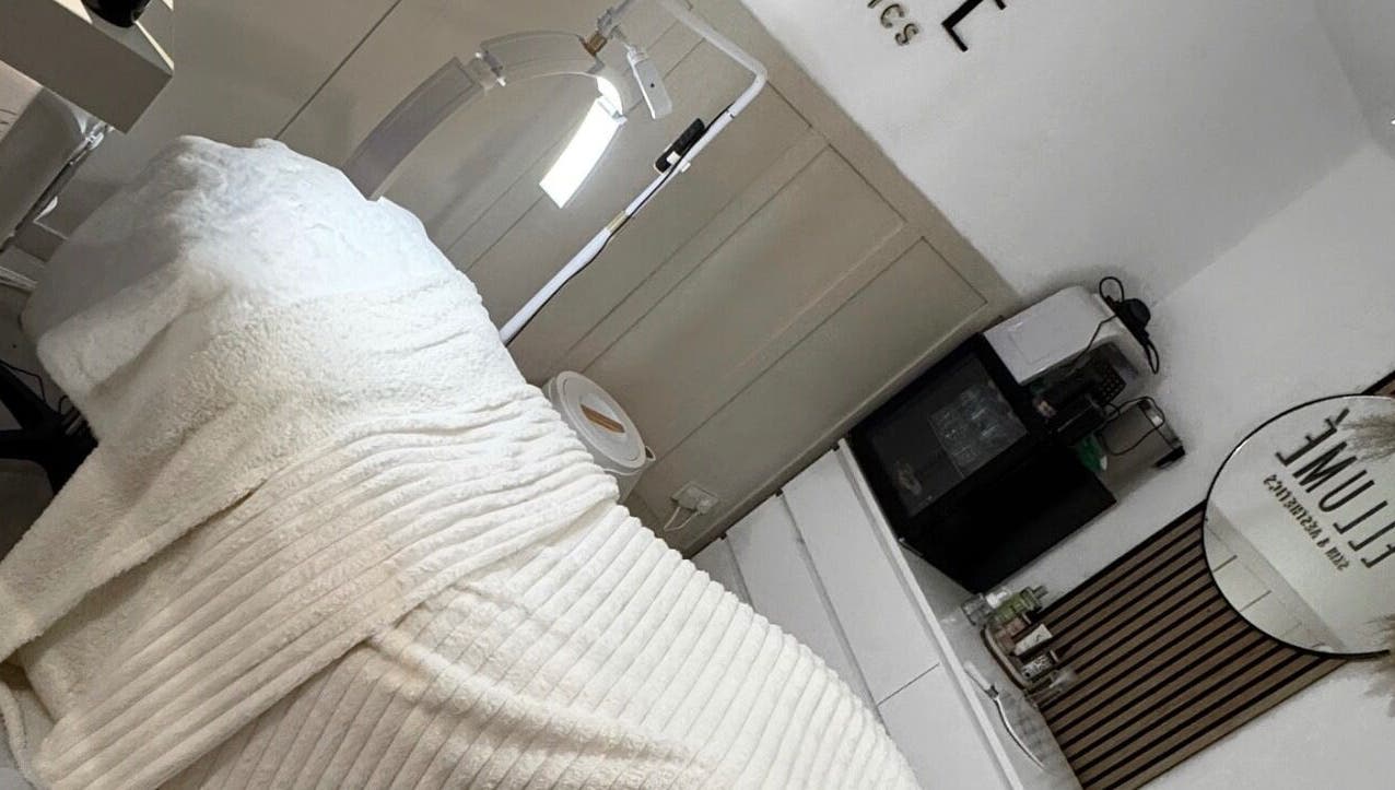 Tranquil treatment room at ELLUME SKIN & AESTHETICS, Little Chalfont, England, GB with cozy blanket and sleek decor.