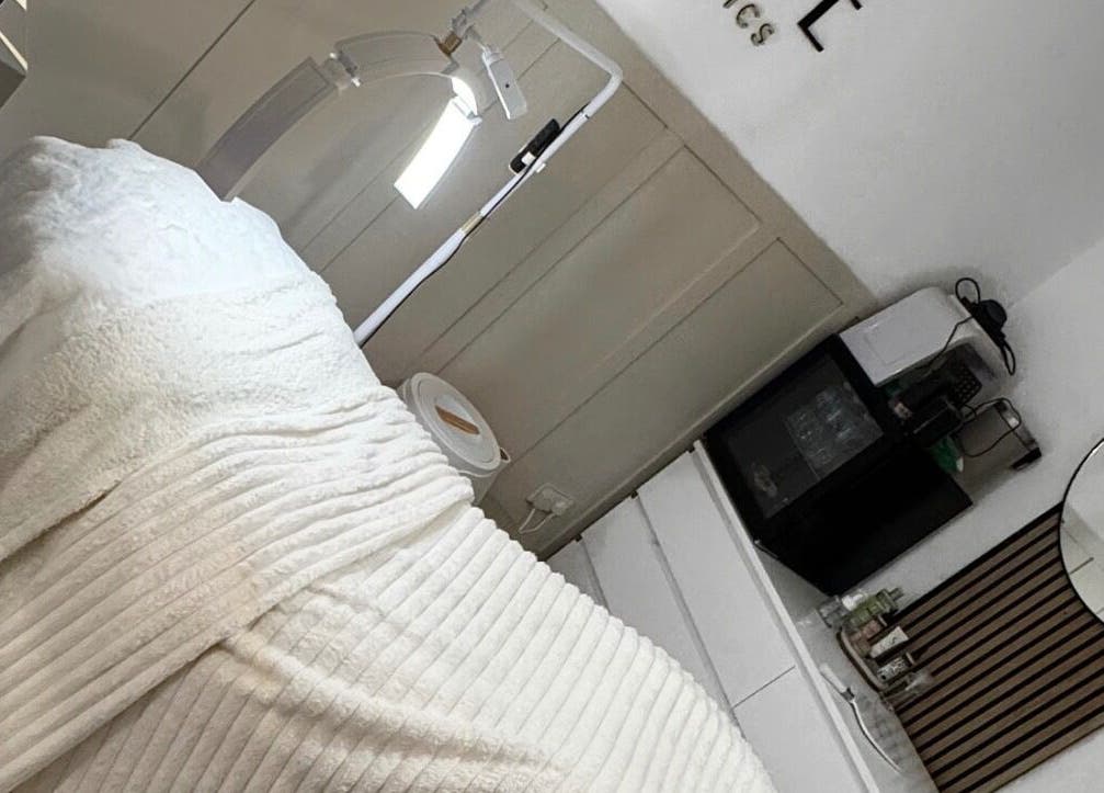 Tranquil treatment room at ELLUME SKIN & AESTHETICS, Little Chalfont, England, GB with cozy blanket and sleek decor.