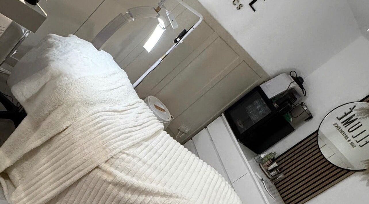 Tranquil treatment room at ELLUME SKIN & AESTHETICS, Little Chalfont, England, GB with cozy blanket and sleek decor.