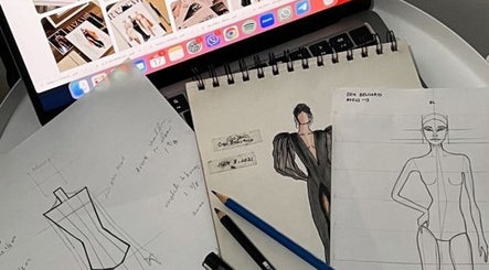 Bocetos y laptop en Taller de costura AJUSTALO, La Negreta, Querétaro, MX, inspirando creatividad.