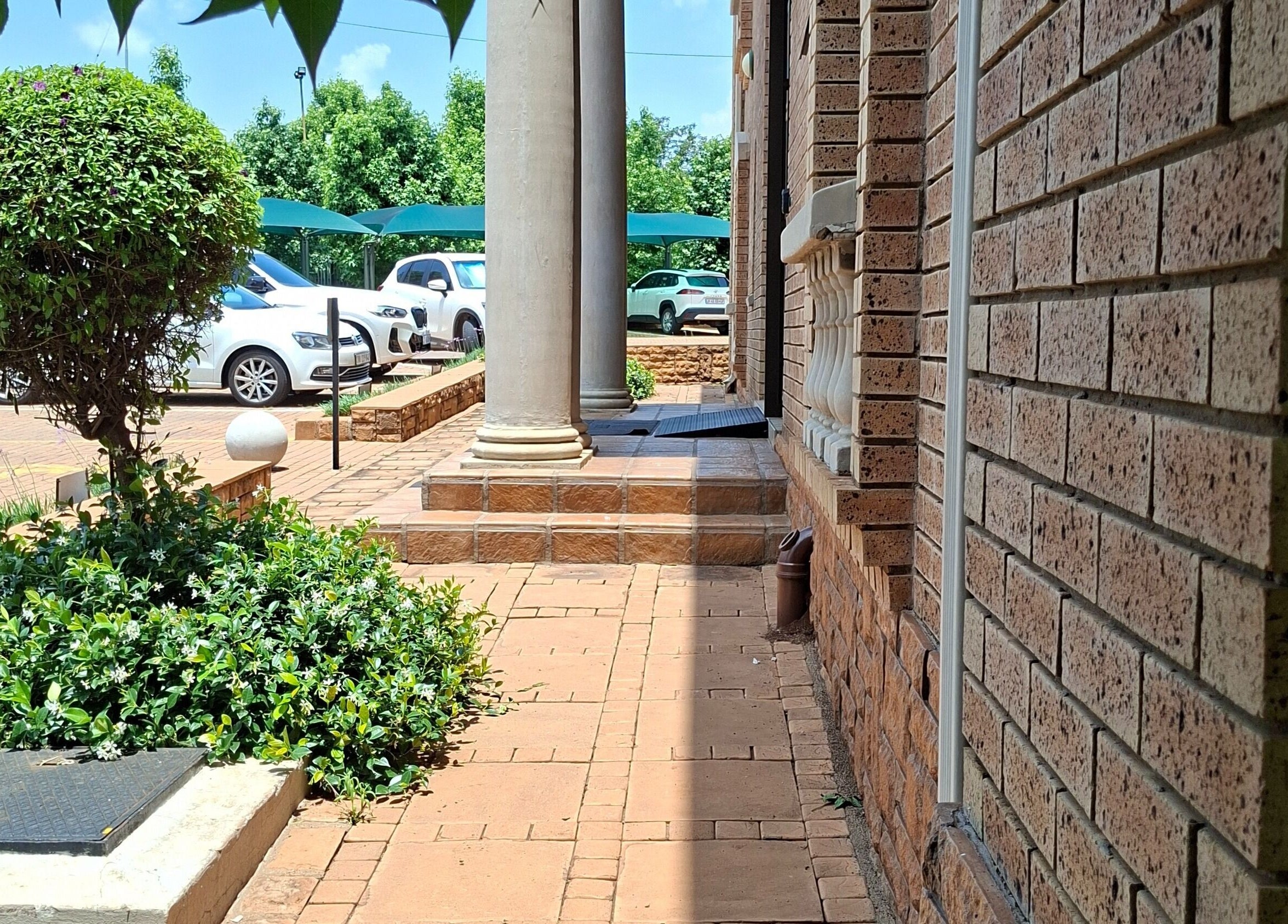 Brick pathway and lush greenery at Enchanted Nails by Tania, Pretoria, Gauteng, ZA.