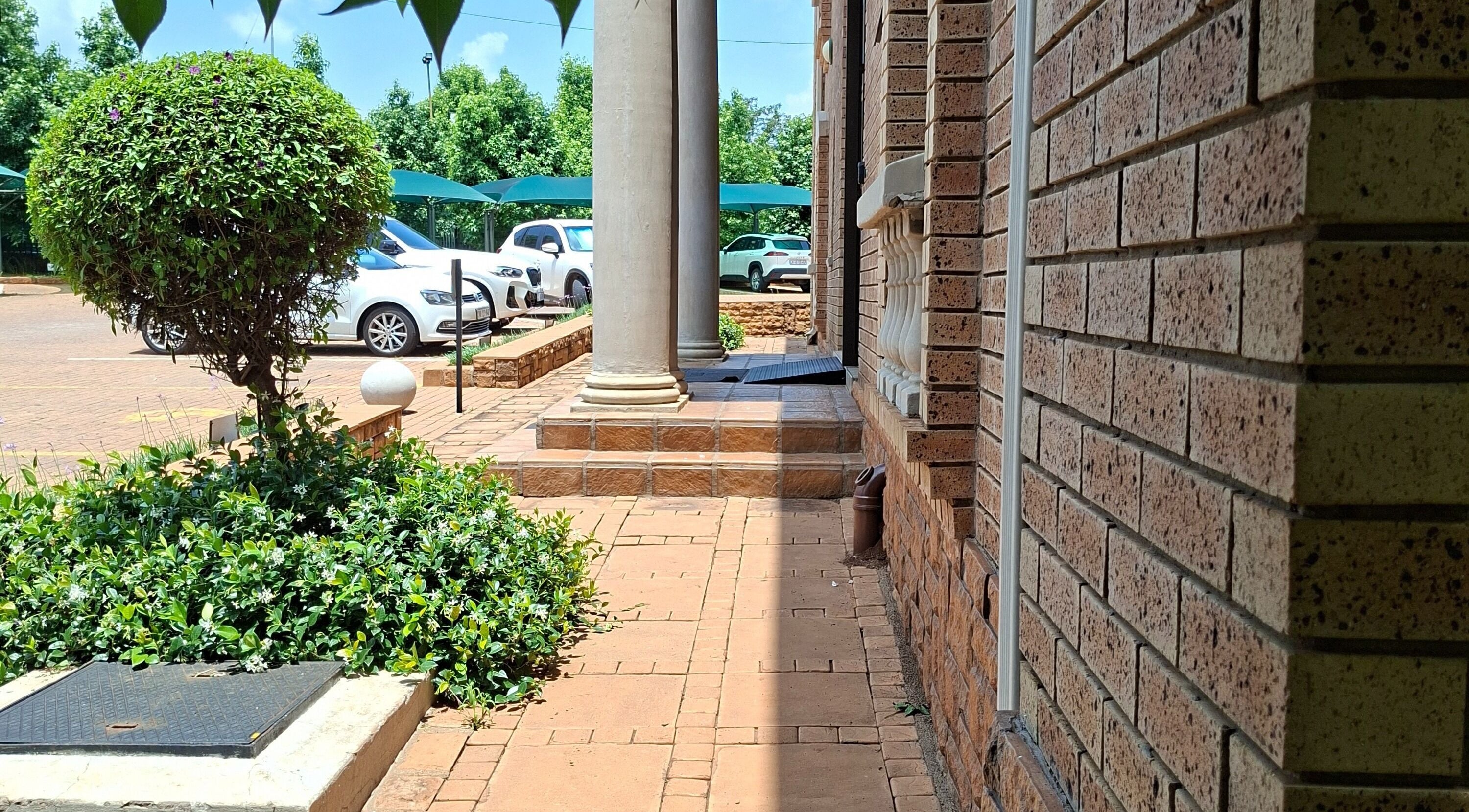 Brick pathway and lush greenery at Enchanted Nails by Tania, Pretoria, Gauteng, ZA.