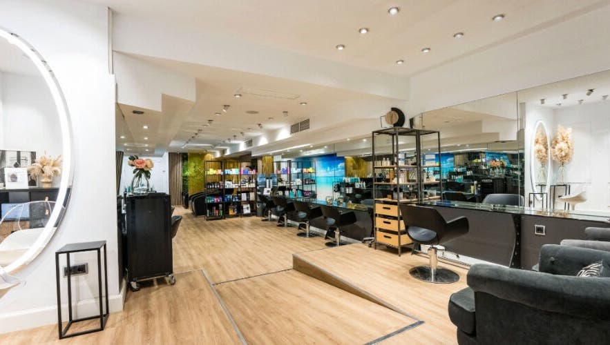 Interior moderno de Le Petit Salon en Barcelona, Catalunya, ES con sillas de peluquería y espejo elegante.