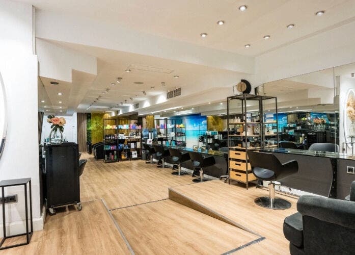 Interior moderno de Le Petit Salon en Barcelona, Catalunya, ES con sillas de peluquería y espejo elegante.