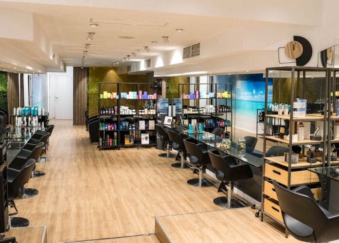 Interior moderno de Le Petit Salon en Barcelona, Catalunya, ES, destacando sillas negras y estanterías de productos.