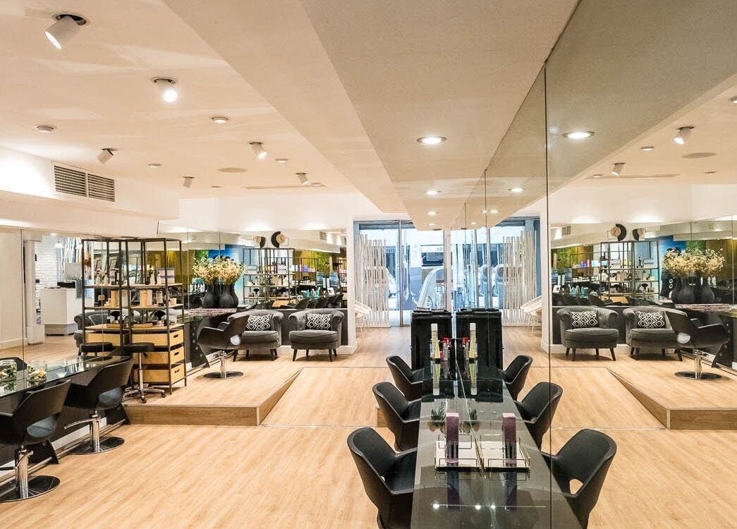 Interior elegante de Le Petit Salon en Barcelona, Catalunya, ES, mostrando sillas modernas y espejos amplios.