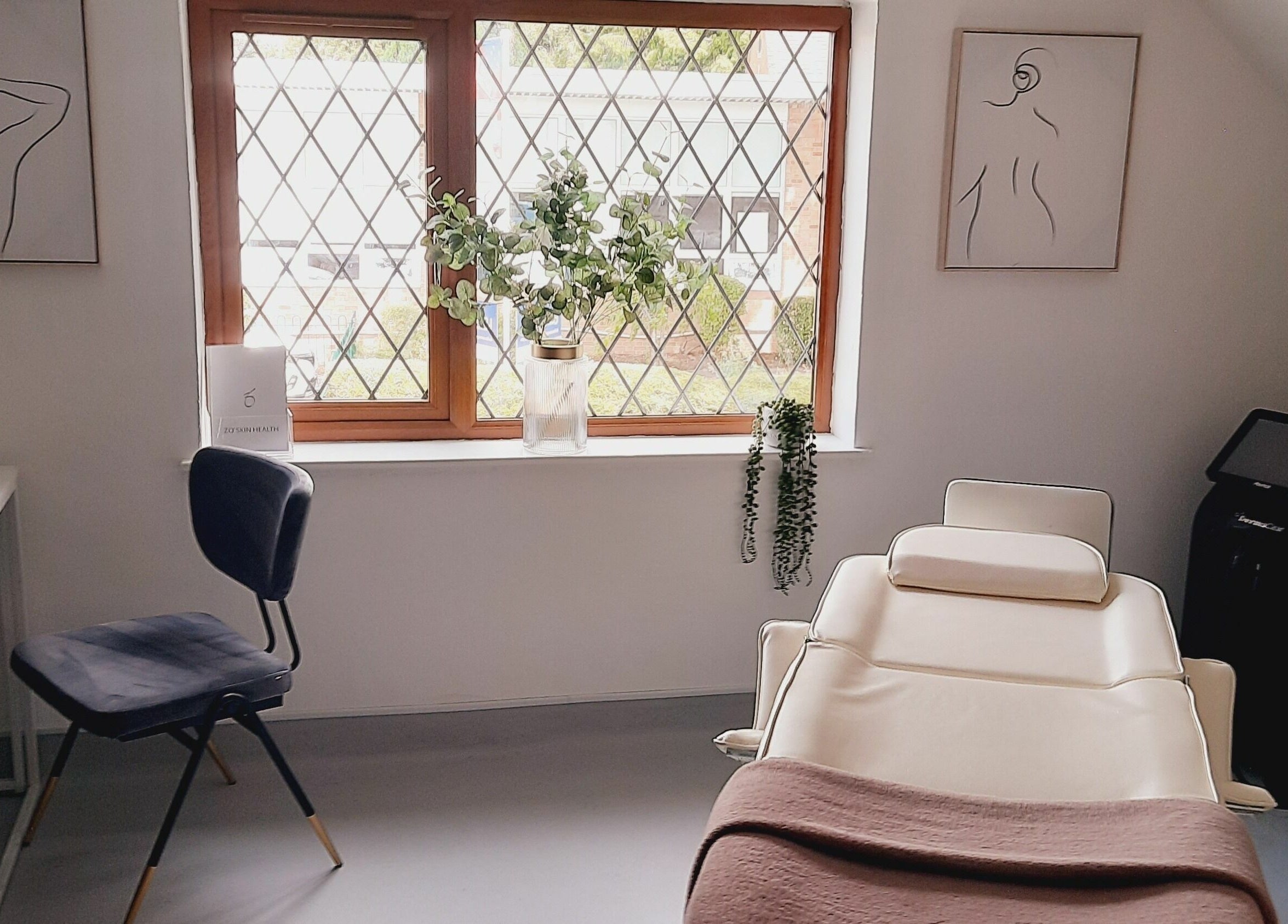 Calming treatment room at Pelo Bonito in Fladbury, England, GB with a beige spa chair and minimalist decor.