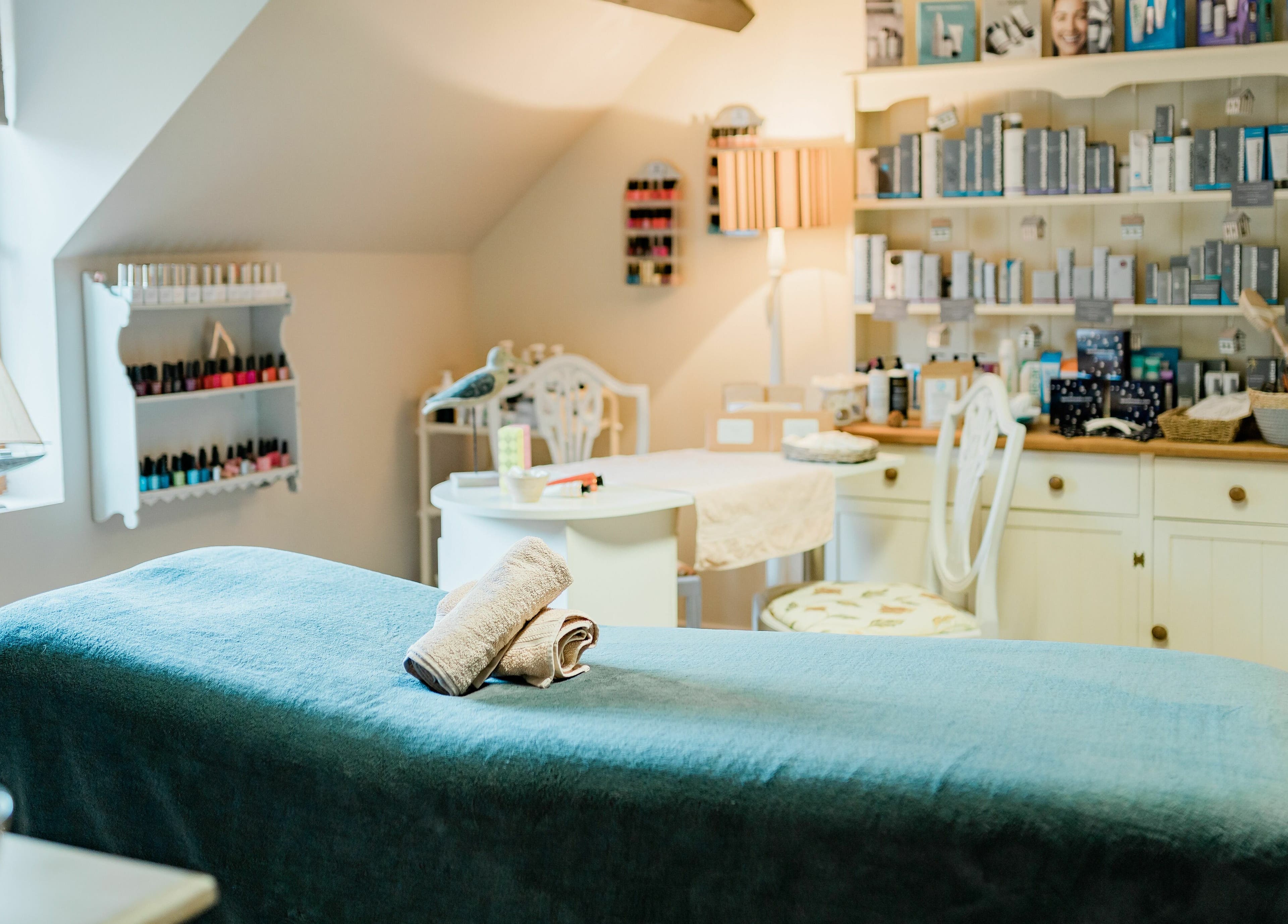 Serene spa room at Pelo Bonito, Fladbury, England, GB, featuring a massage table and calming decor.
