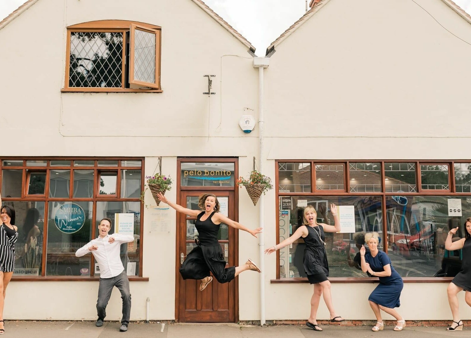 Happy team outside Pelo Bonito, Fladbury, England, GB, showcasing warm ambiance and welcoming facade.