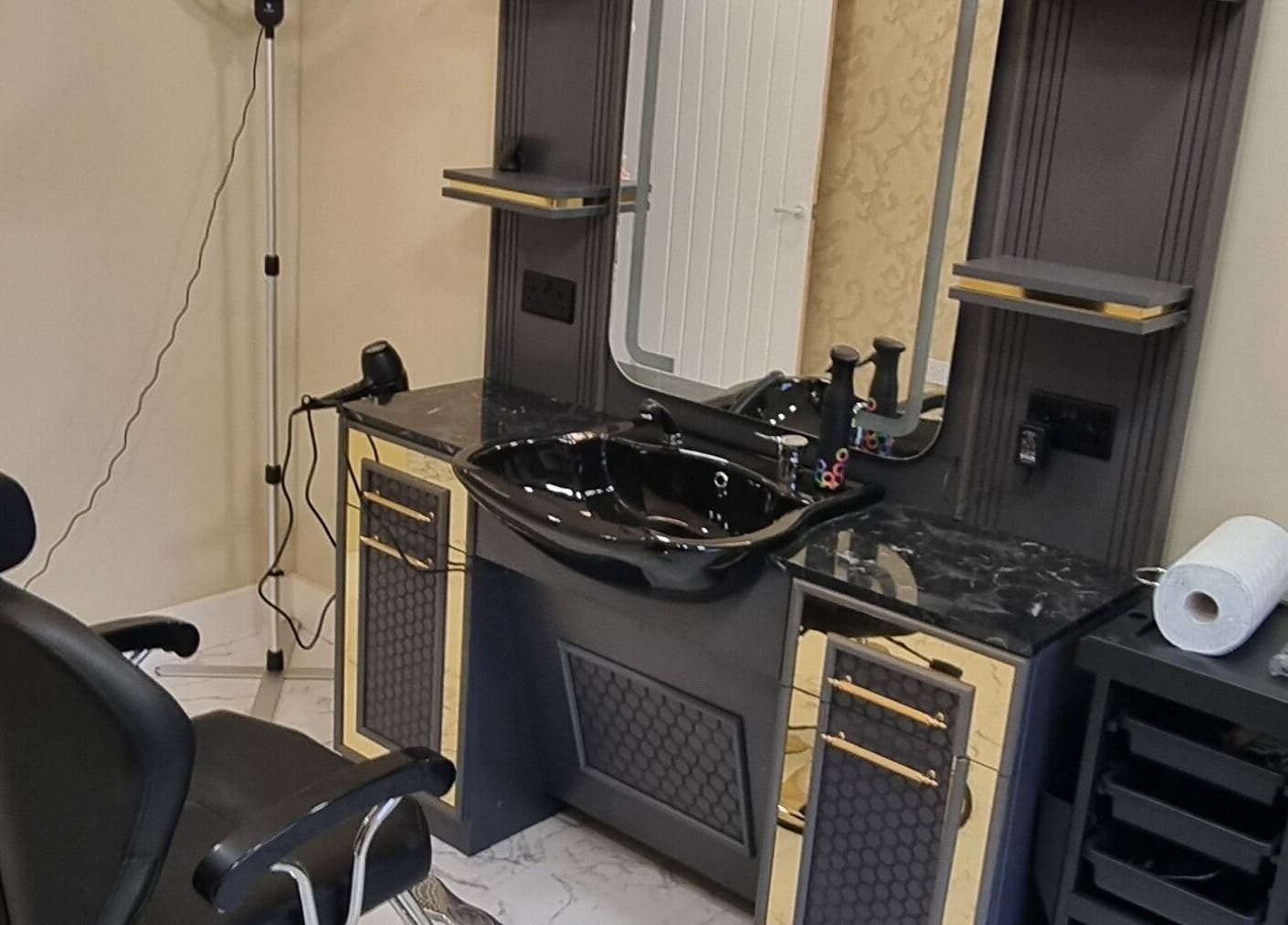Luxurious styling station at Charles Hair Reaper Ponteland, Ponteland, England, GB featuring sleek black decor.
