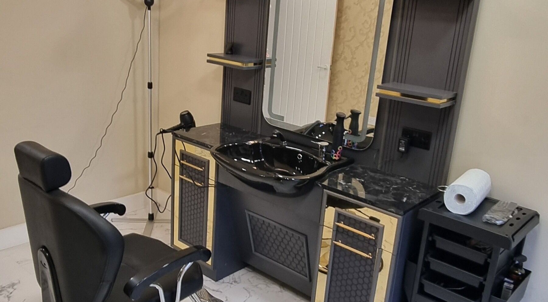 Luxurious styling station at Charles Hair Reaper Ponteland, Ponteland, England, GB featuring sleek black decor.