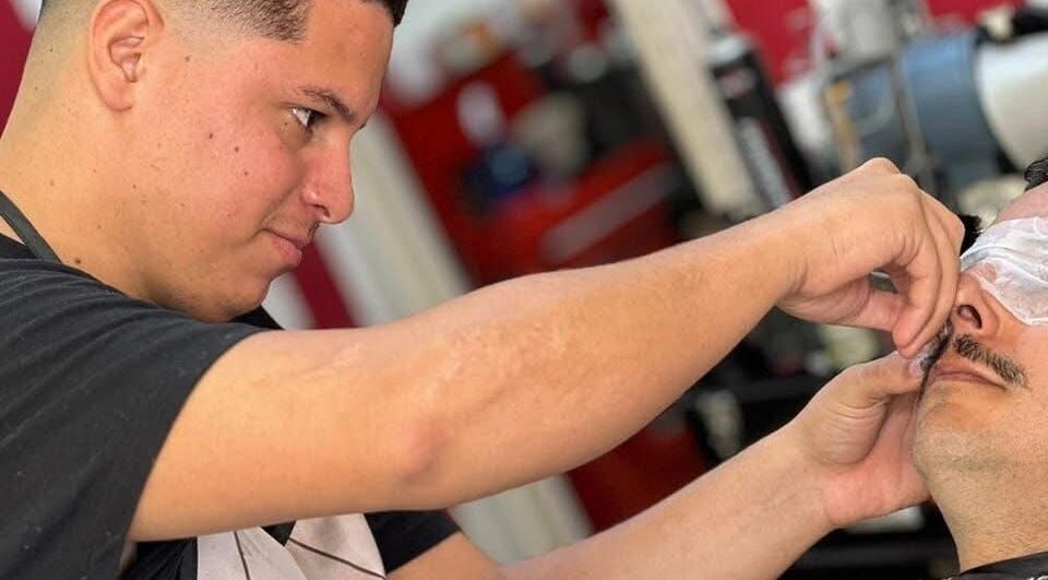 Barbero trabajando en Barbería Identidad en Palmira, Valle Del Cauca, CO, cuidando detalle del cliente.