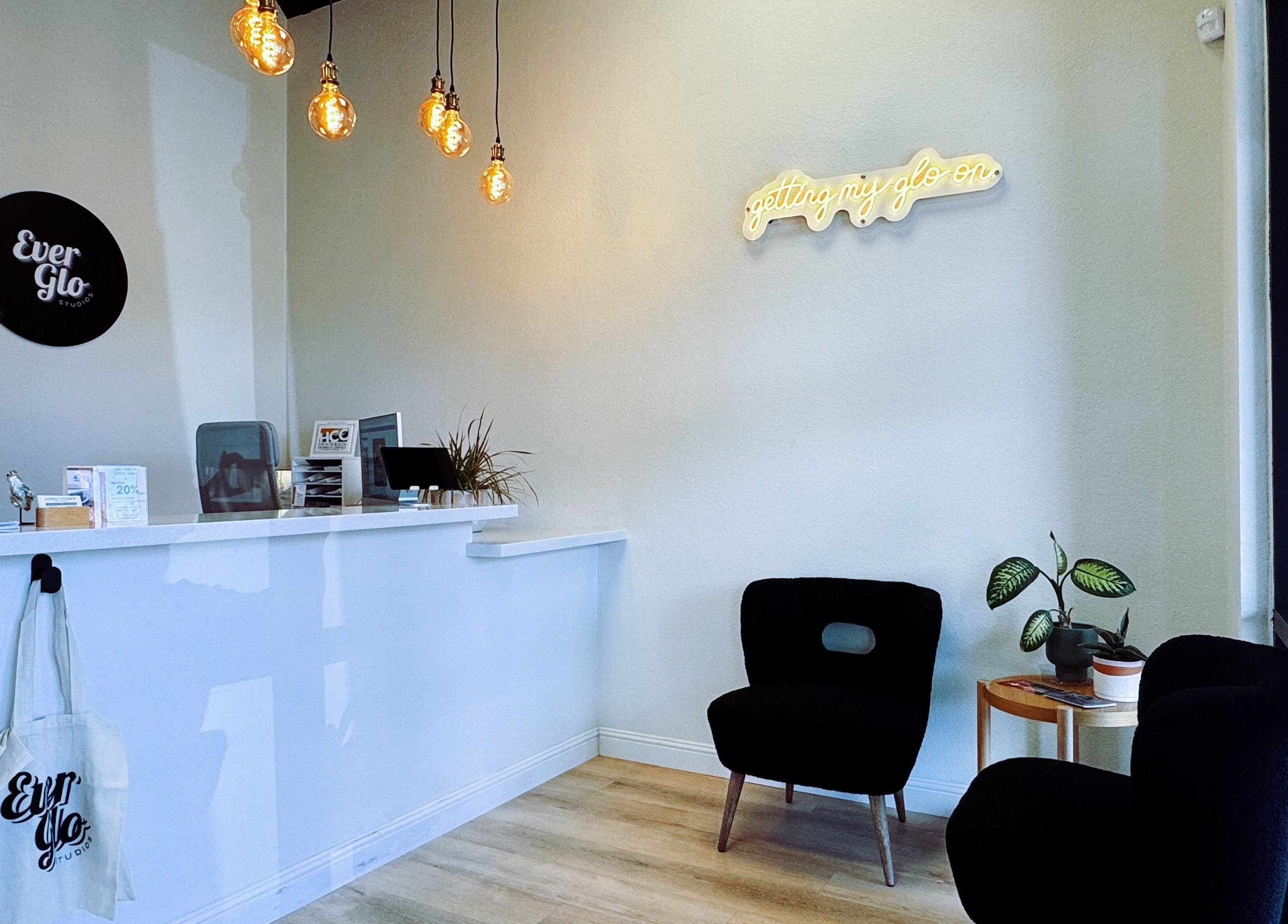 Reception area of EverGlo Studios, Henderson, Nevada, with modern decor and warm lighting.