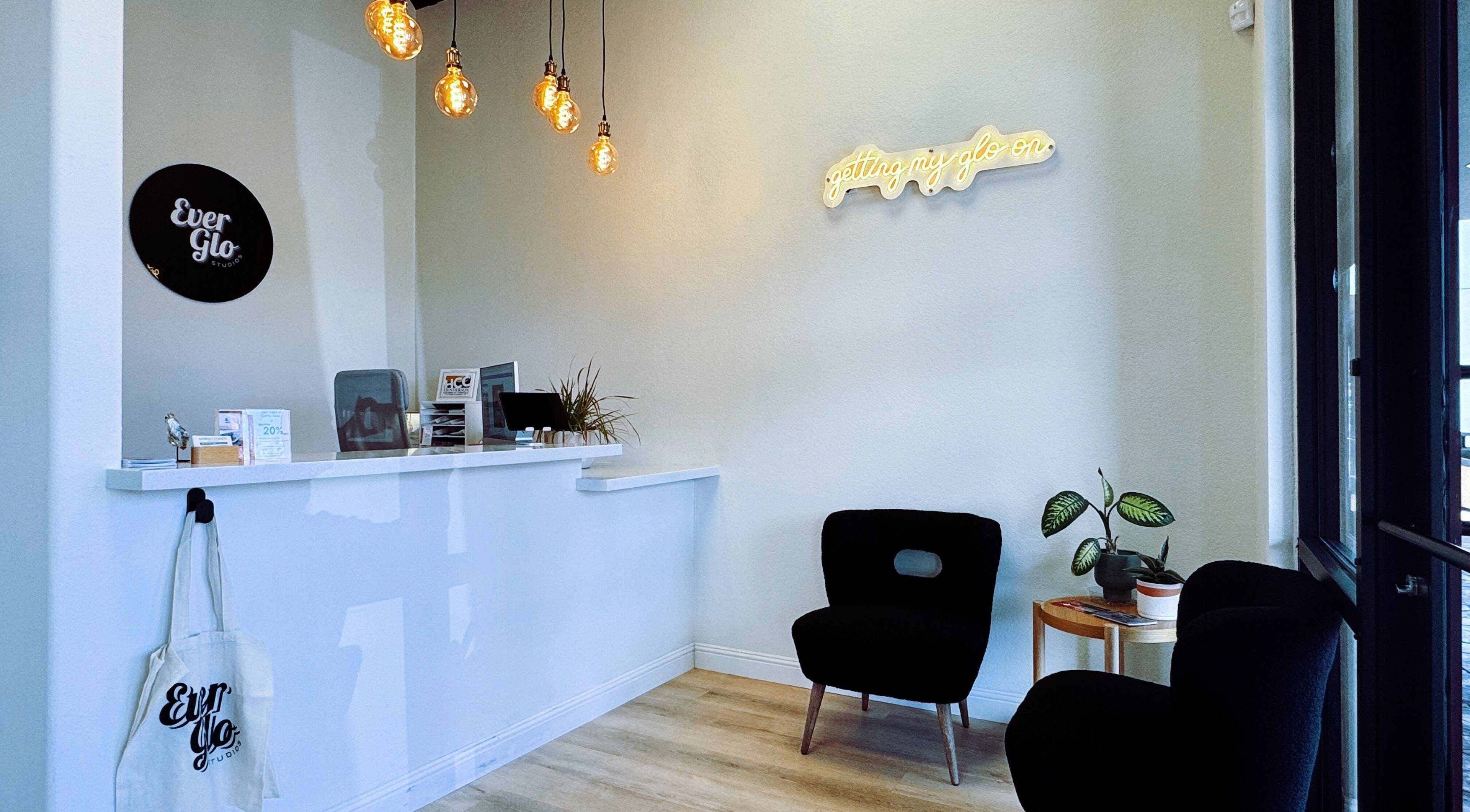 Reception area of EverGlo Studios, Henderson, Nevada, with modern decor and warm lighting.