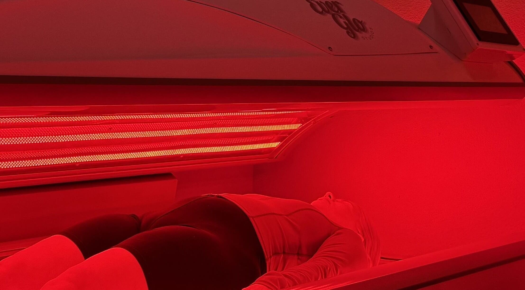 Person in red light therapy at EverGlo Studios, Henderson, Nevada, US for skin rejuvenation.