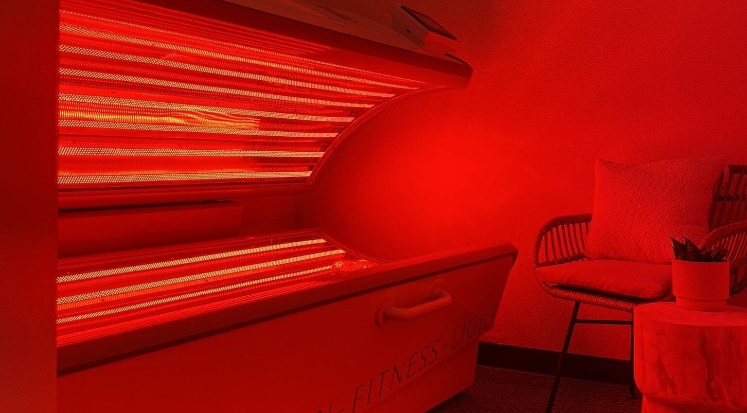 Warm, inviting red light therapy room at EverGlo Studios, Henderson, Nevada, US, featuring a cozy chair.