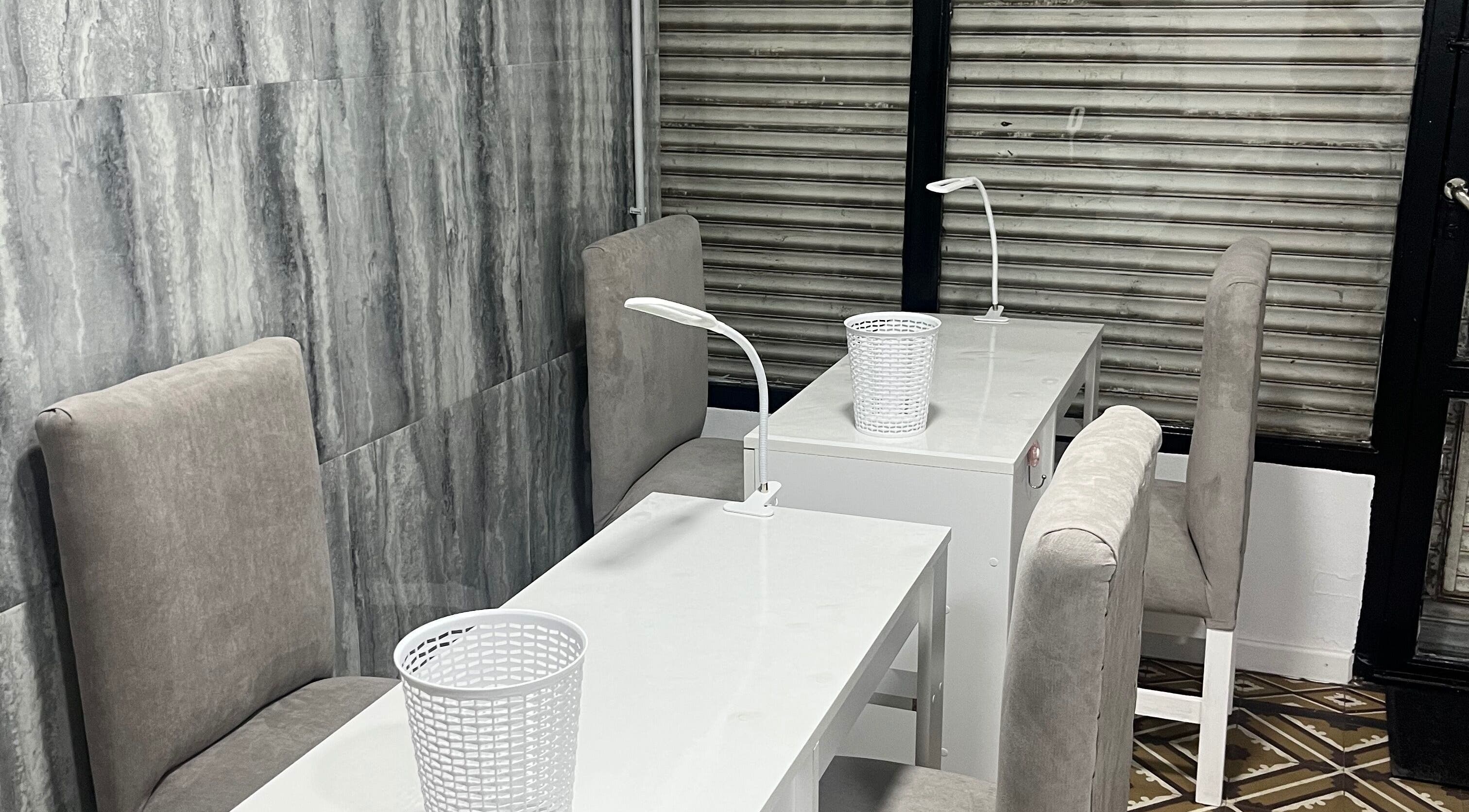 Modern nail care stations at Norma.BeautyStudio, Rosario, Santa Fe, AR with sleek white tables and chairs.