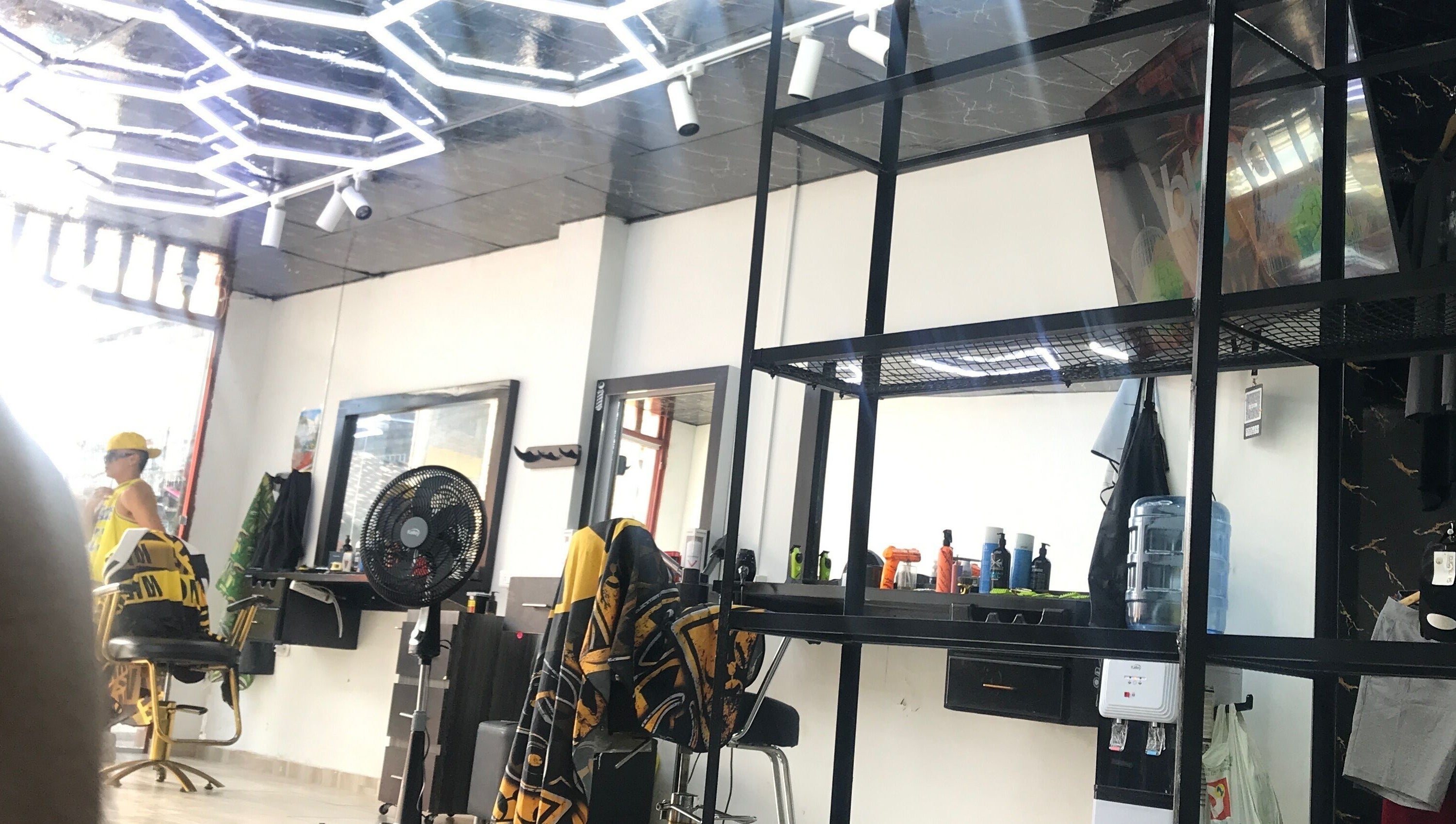 Salón moderno en Mjlux_e, Valle Del Cauca, CO, con iluminación de neón y sillas estilísticas.