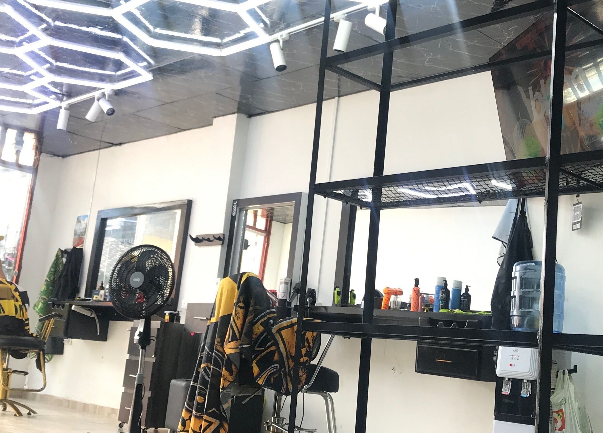 Salón moderno en Mjlux_e, Valle Del Cauca, CO, con iluminación de neón y sillas estilísticas.