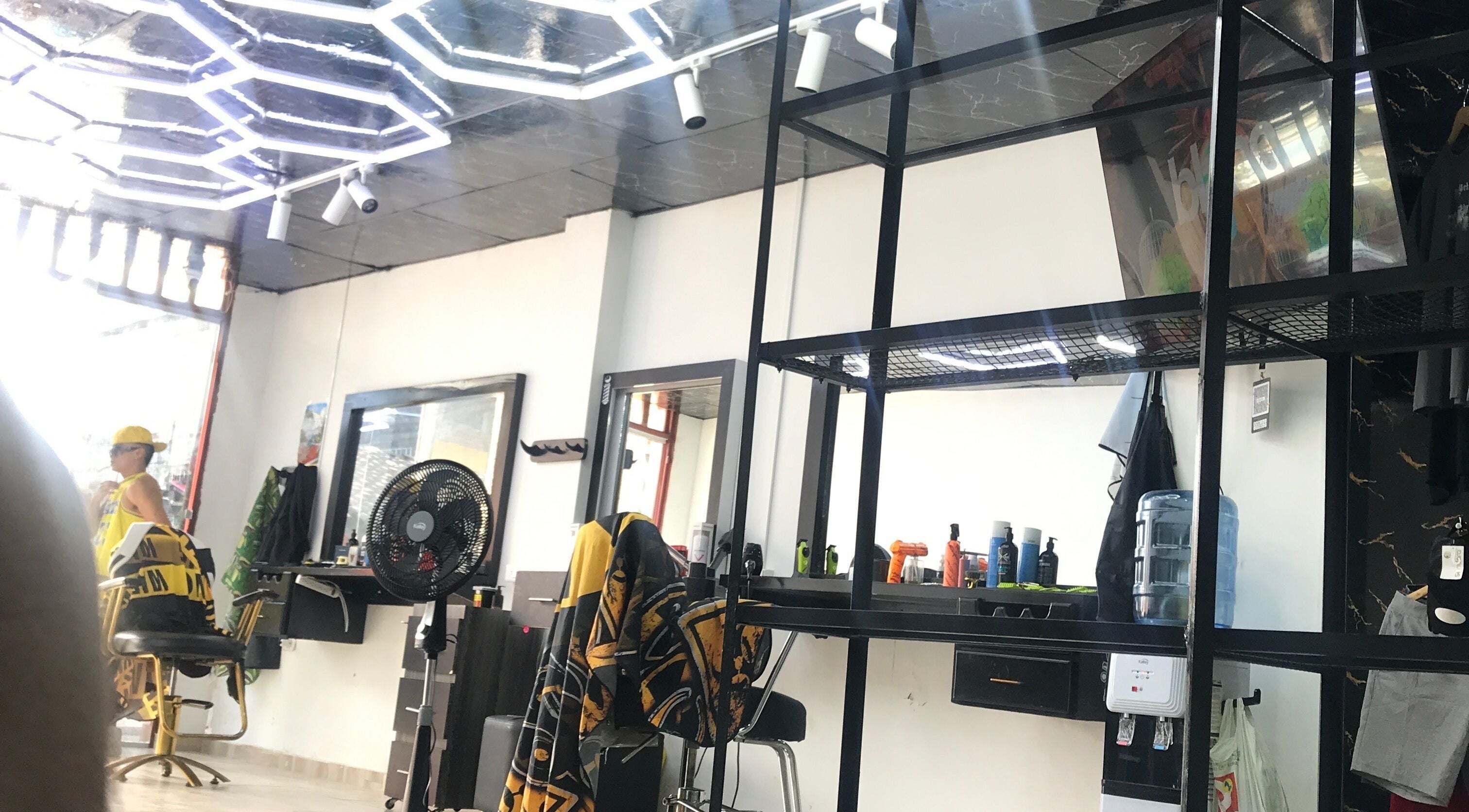 Salón moderno en Mjlux_e, Valle Del Cauca, CO, con iluminación de neón y sillas estilísticas.